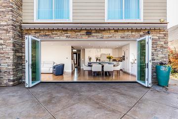large white accordion glass doors opened from center looking into modern dining room
