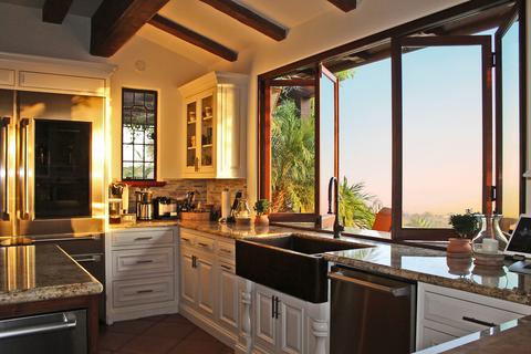 A folding kitchen passthrough window partially open at sunset.